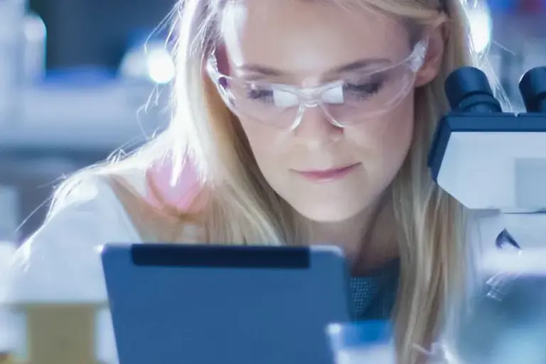 Close-up of the face of a scientist close to her microscope