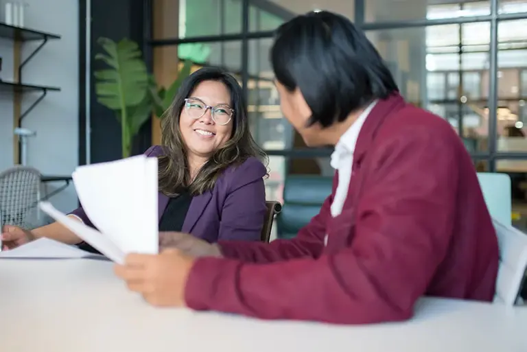 Two office workers chatting happily over a table