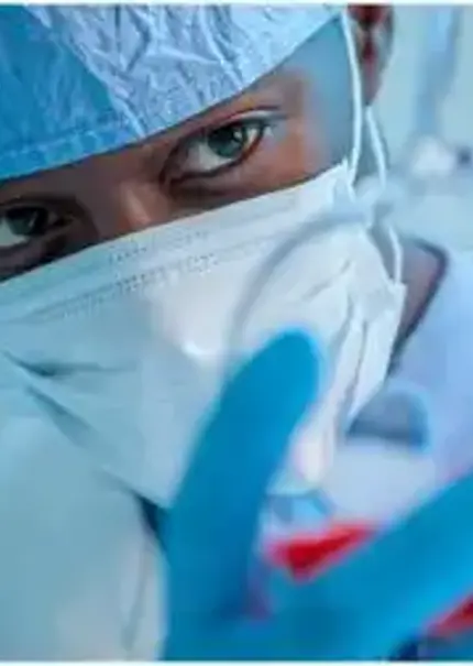 A masked scientist holds a chemical glass flask full of liquid