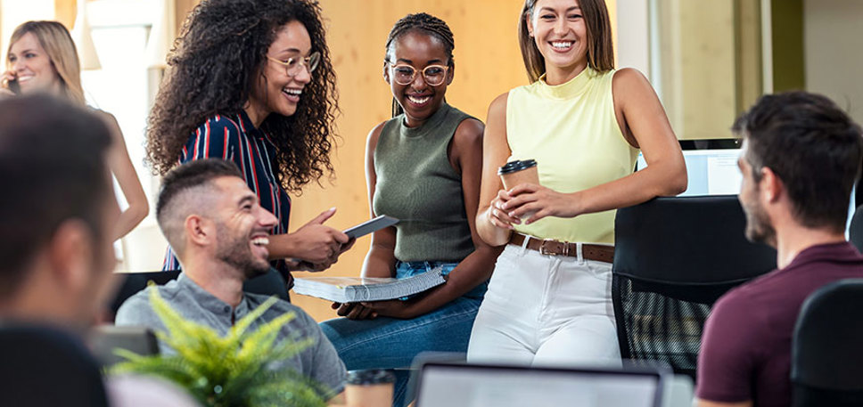 A mixed group of young people smiling and working in an office setting