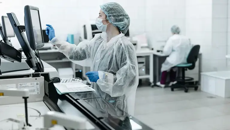 Scientist inputting on a touch screen in a laboratory