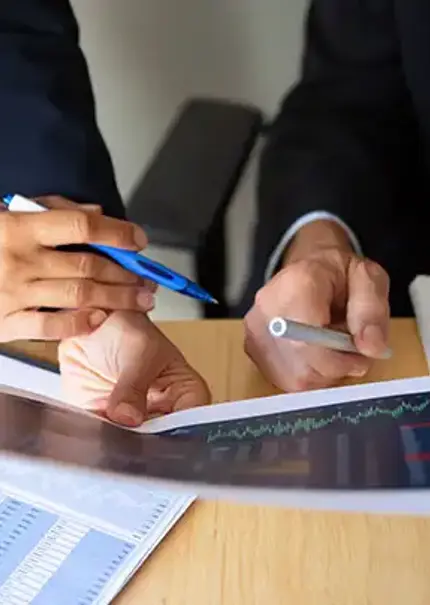 Close up of the hands of two office workers holding print outs of charts