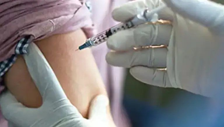 Close up of a health care professional administering an injection in a patient's arm